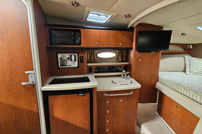 Slide: The Image of 2004 Chaparral Signature 310 interior with kitchenette, microwave, TV, and bed. - 20