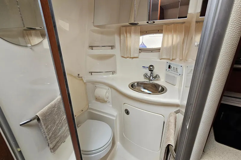 Slide: The Image of 2004 Chaparral Signature 310 boat bathroom with sink, toilet, and storage shelves. - 24