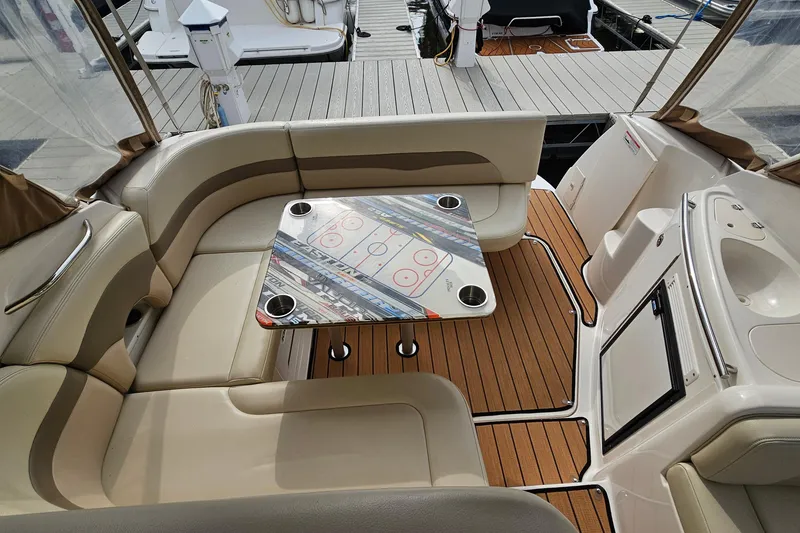 Slide: The Image of 2004 Chaparral Signature 310 boat interior with seating and a table, docked at a marina. - 8