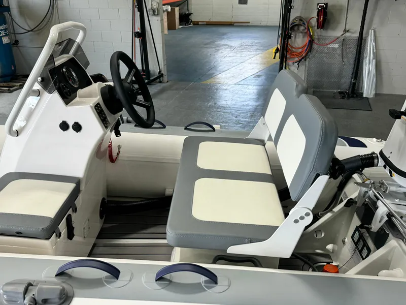 Slide: The Image of 2024 Highfield Classic 380 Grand Tour boat interior with steering wheel and cushioned seats. - 11