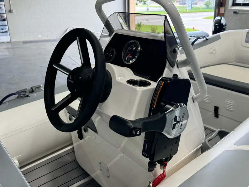 Slide: The Image of 2024 Highfield Classic 380 Grand Tour boat dashboard with steering wheel and controls. - 12