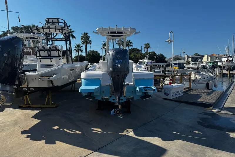 Slide: The Image of 2026 Caymas 24 HB boat with Yamaha engine, docked under clear blue sky. - 11