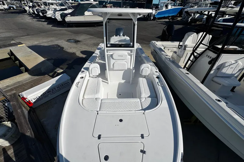 Slide: The Image of 2026 Caymas 24 HB boat with Yamaha engine, docked under clear blue sky. - 13
