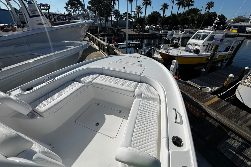 Slide: The Image of 2026 Caymas 24 HB boat docked at marina, featuring spacious deck and seating. - 15