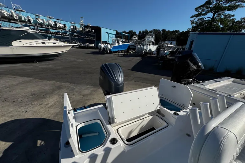 Slide: The Image of 2026 Caymas 24 HB boat with open storage compartments docked at a marina. - 17
