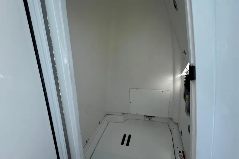 Slide: The Image of 2026 Caymas 24 HB boat in marina, showcasing open storage compartments and outboard motor. - 18