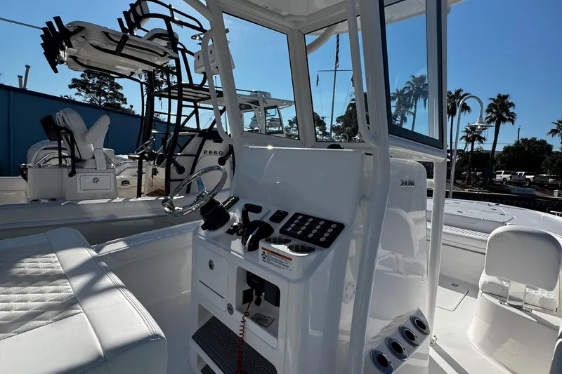 Slide: The Image of 2026 Caymas 24 HB boat helm with steering wheel and control panel. - 21