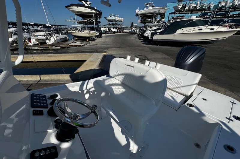 Slide: The Image of 2026 Caymas 24 HB boat with rod holders and speaker, docked under clear blue sky. - 23