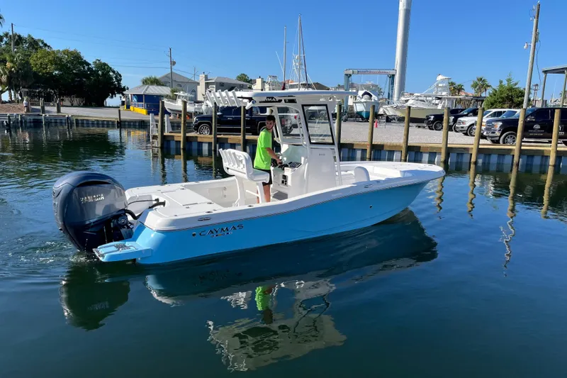 Slide: The Image of 2026 Caymas 24 HB boat on calm water near a marina, clear blue sky. - 3