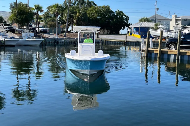 Slide: The Image of 2026 Caymas 24 HB boat on calm water near a marina with palm trees. - 6