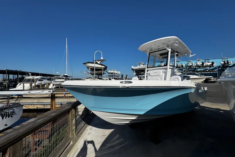 Slide: The Image of 2026 Caymas 24 HB boat displayed at a marina under clear blue skies. - 9