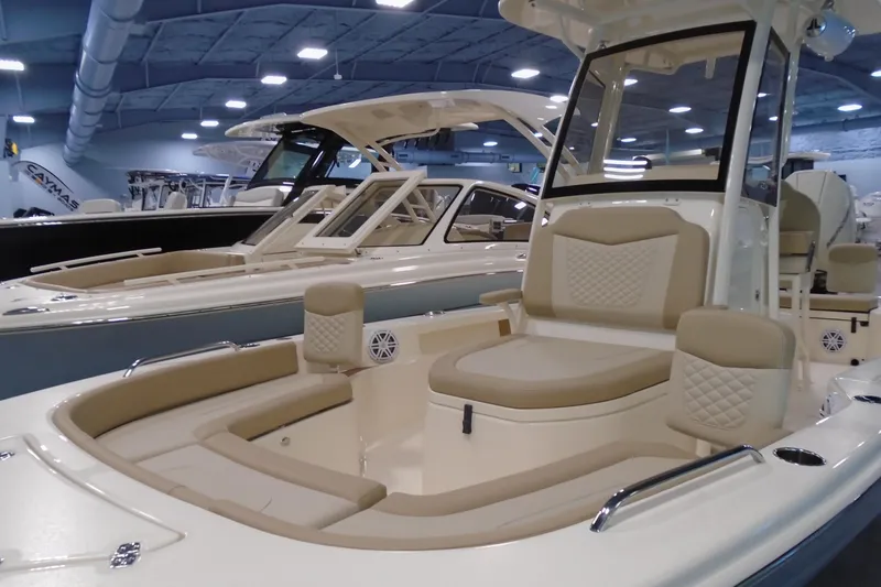 Slide: The Image of 2026 Scout 231 XSB boat with beige seating, showcased indoors. - 14