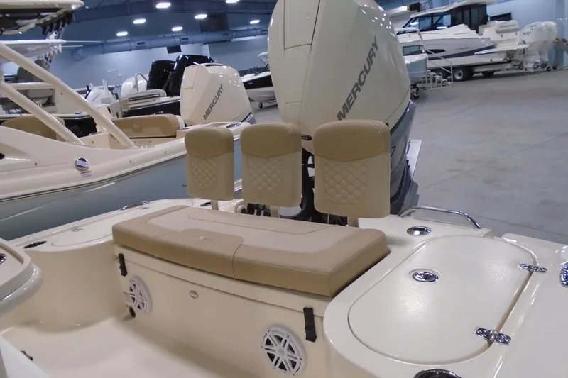 Slide: The Image of 2026 Scout 231 XSB boat interior with beige seating and Mercury engine in showroom. - 15