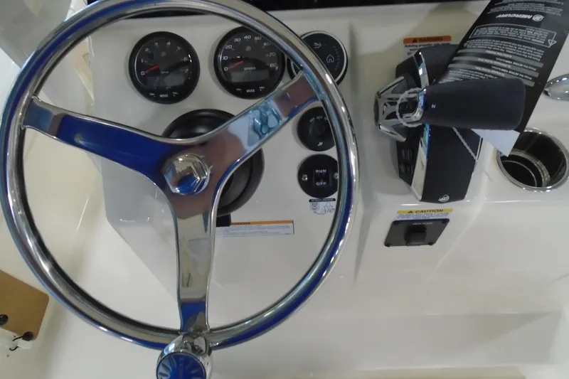 Slide: The Image of Steering wheel and controls of 2026 Scout 231 XSB boat dashboard. - 23