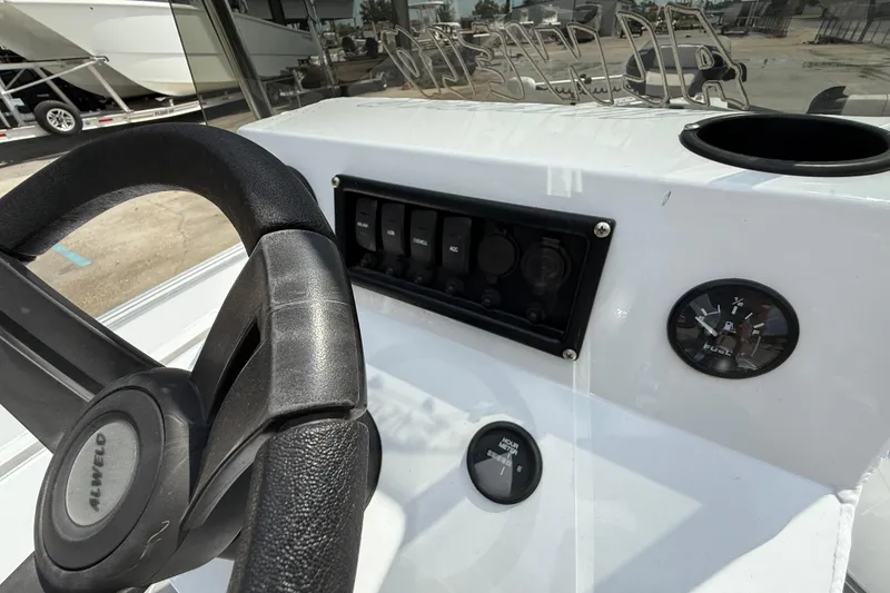 Slide: The Image of 2024 Alweld 2070cc boat dashboard with steering wheel and fuel gauge. - 13