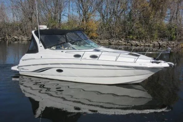 The Image of 2000 Chaparral Signature 300 boat on calm water, surrounded by trees. - 0