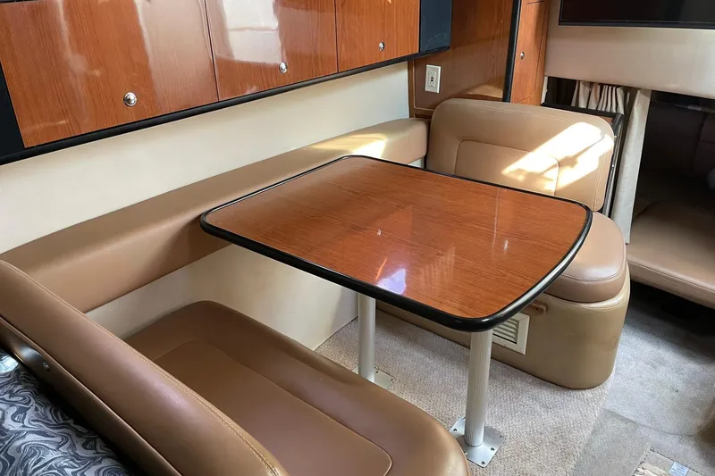 Slide: The Image of Interior of 2000 Chaparral Signature 300, featuring a wooden dining table and leather seating. - 18