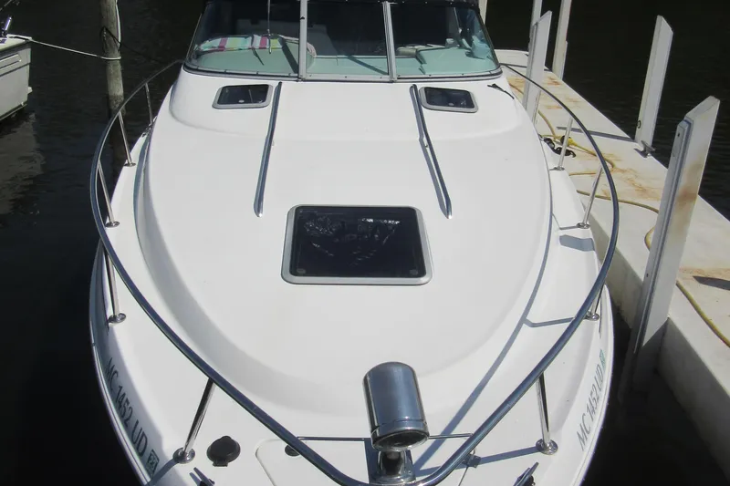 Slide: The Image of 2000 Chaparral Signature 300 boat docked, featuring sleek white design and spacious deck. - 2