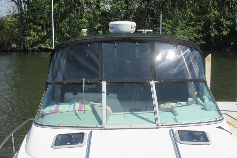 Slide: The Image of Chaparral Signature 300 boat, 2000 model, docked by a lush riverside. - 3