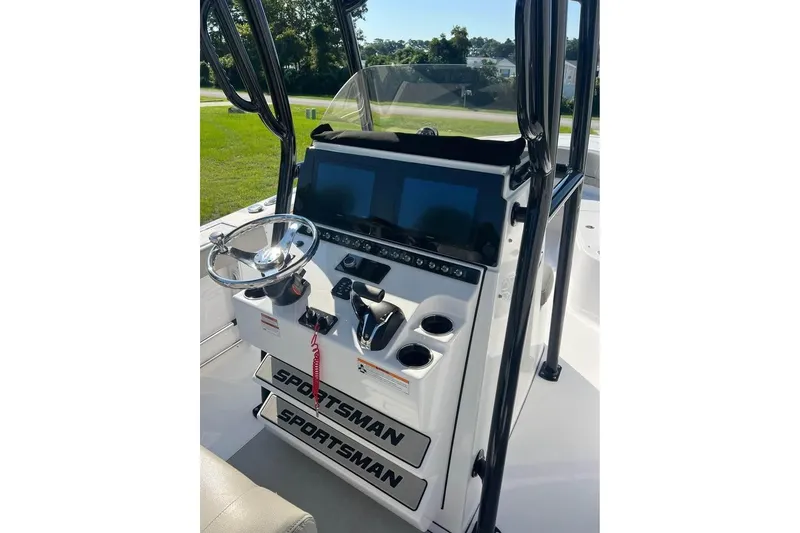 Slide: The Image of 2023 Sportsman Open 242 Center Console boat dashboard with steering wheel and controls. - 2