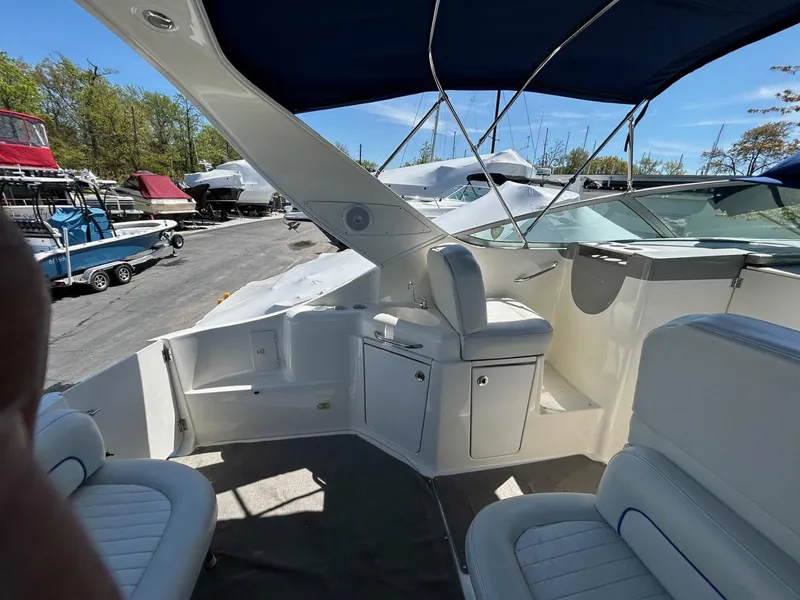 Slide: The Image of 2007 Bayliner 305 boat interior with seating, under a blue canopy, docked outdoors. - 10