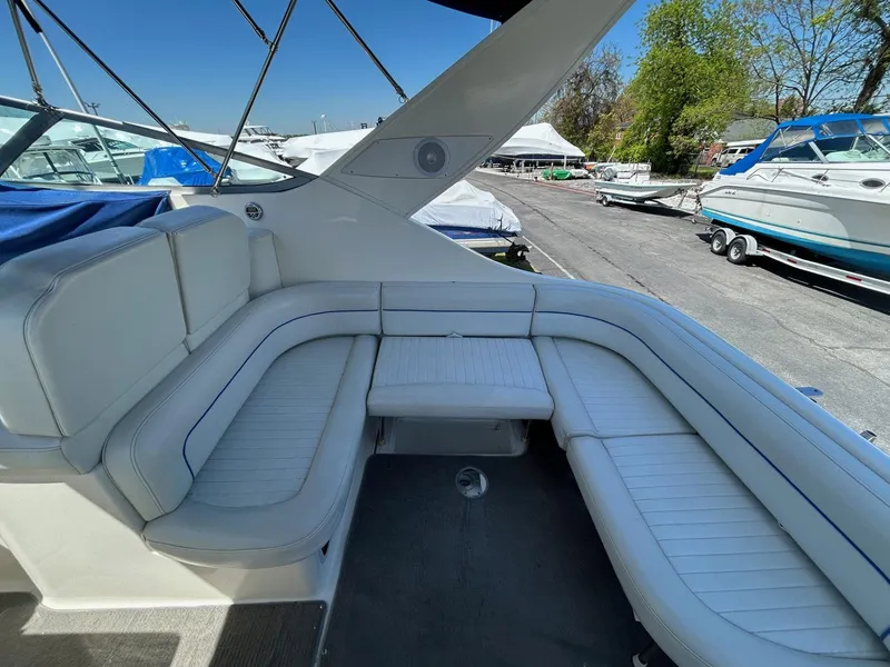 Slide: The Image of 2007 Bayliner 305 boat interior with white cushioned seating and outdoor marina view. - 9