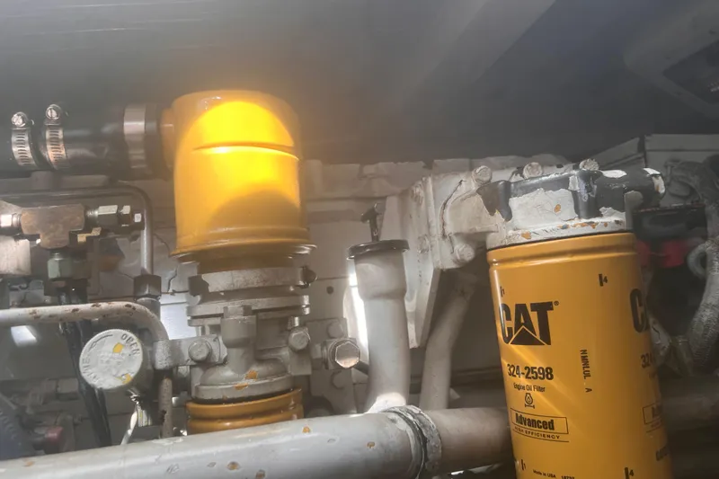 Slide: The Image of Engine components of a 2001 Cabo 31 Express boat, featuring CAT oil filters. - 25