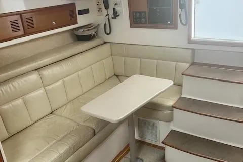 Slide: The Image of 2001 Cabo 31 Express boat deck with seating and storage, docked on calm water. - 8