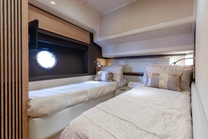 Slide: The Image of Luxurious twin cabin interior on 2014 Azimut 60 Flybridge yacht, featuring elegant bedding and porthole. - 18