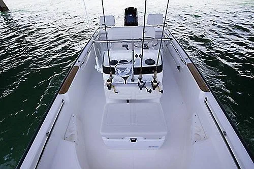 Slide: The Image of 2026 Boston Whaler 170 Montauk boat interior with fishing rods on open water. - 5