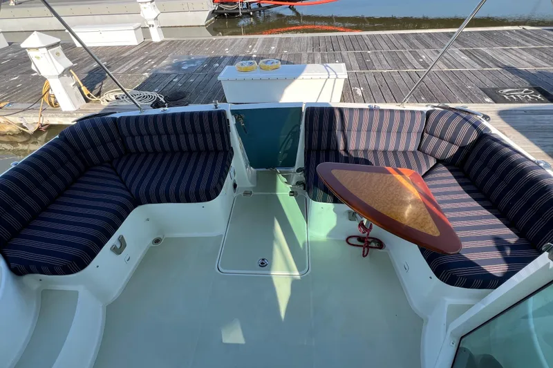 Slide: The Image of 2016 Back Cove 37 boat with striped seating and a wooden table on deck. - 15