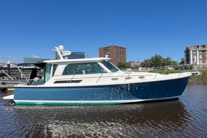 Slide: The Image of 2016 Back Cove 37 boat on calm water, blue hull, clear sky background. - 2