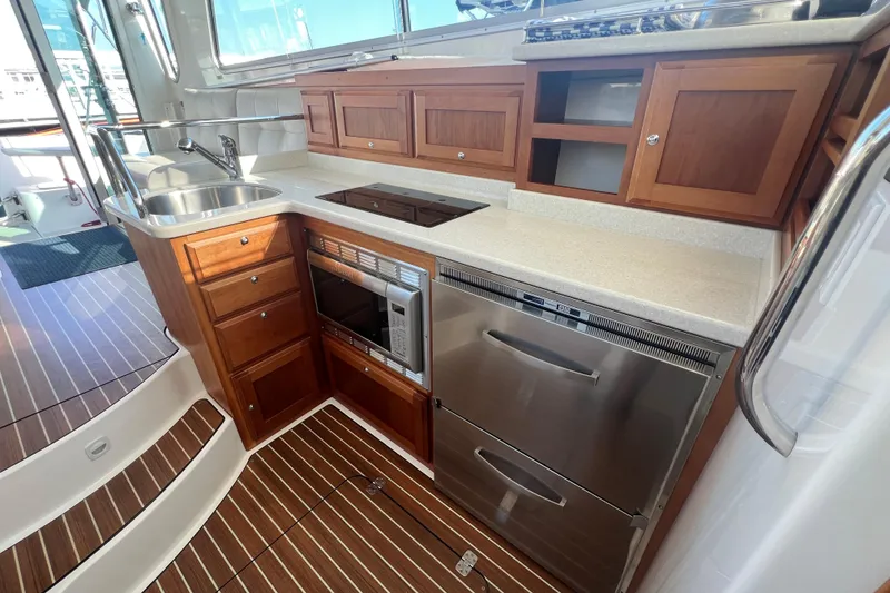 Slide: The Image of 2016 Back Cove 37 yacht kitchen with wood cabinetry, stainless appliances, and modern fixtures. - 20