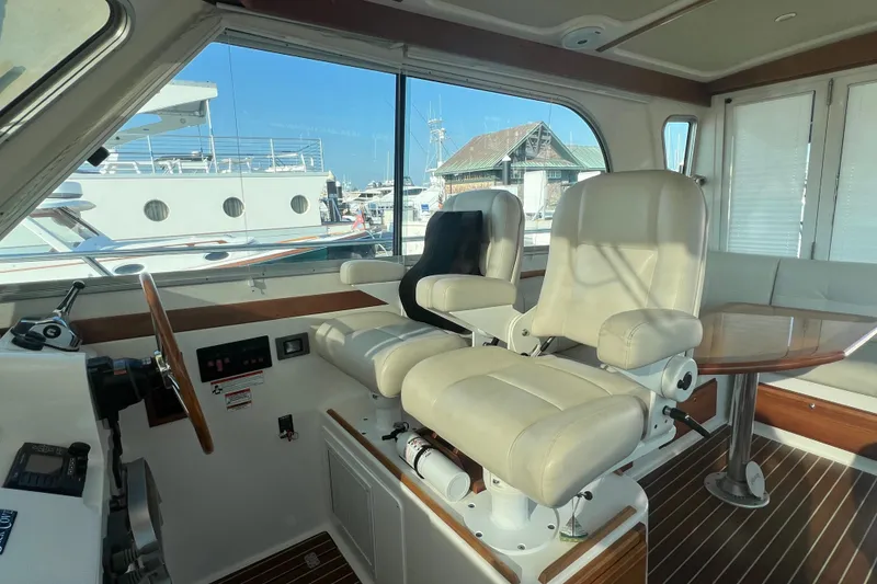 Slide: The Image of Interior of a 2016 Back Cove 37 yacht with helm seats and a wooden table. - 21