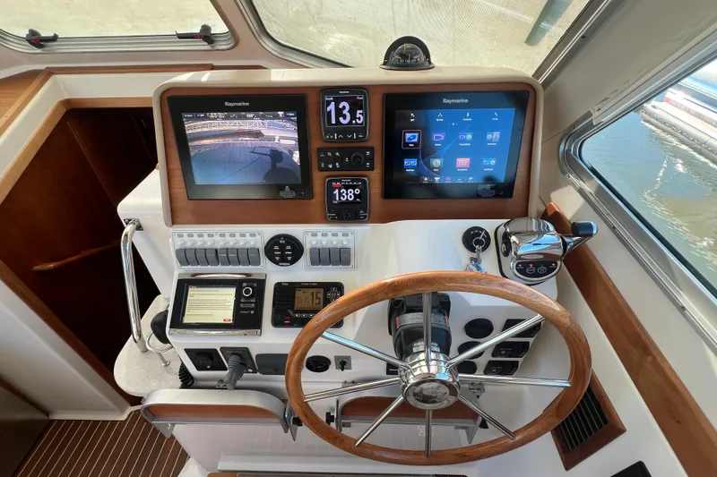Slide: The Image of Helm of 2016 Back Cove 37 boat with advanced navigation displays and wooden steering wheel. - 22