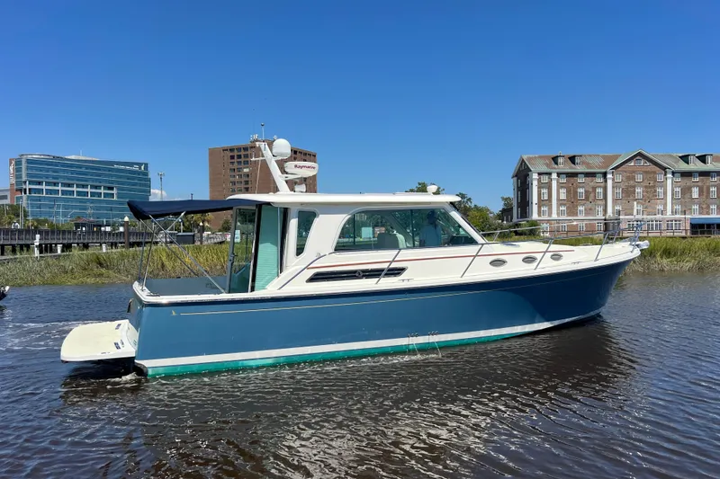 Slide: The Image of 2016 Back Cove 37 boat on water, urban buildings in background, clear blue sky. - 4