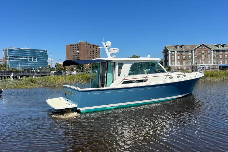 Slide: The Image of 2016 Back Cove 37 boat cruising on a sunny day near waterfront buildings. - 5