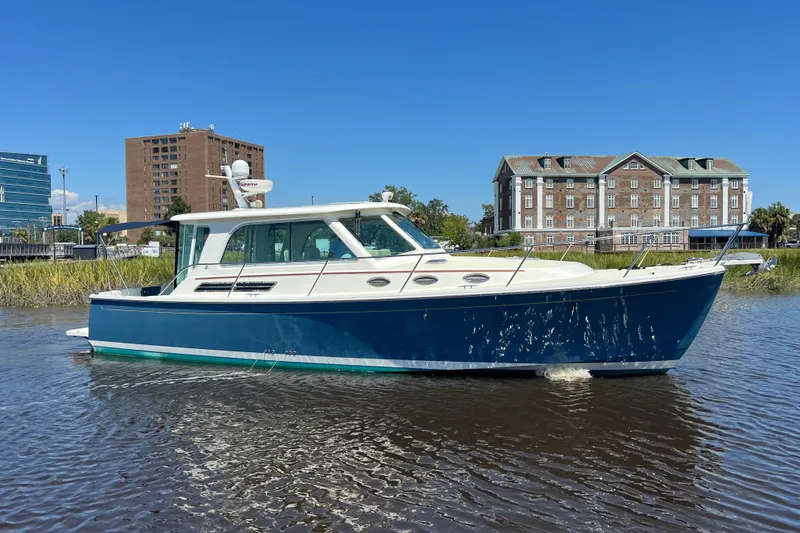 Slide: The Image of 2016 Back Cove 37 boat cruising on a sunny day near waterfront buildings. - 6