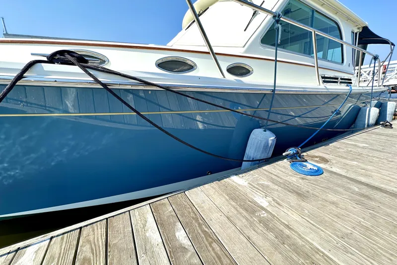 Slide: The Image of 2016 Back Cove 37 yacht docked, showcasing sleek blue hull and elegant design. - 8