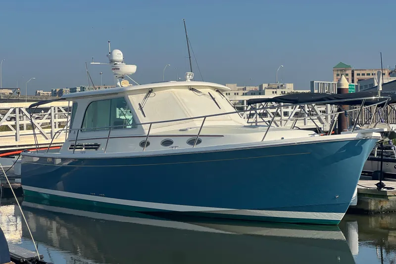 Slide: The Image of 2016 Back Cove 37 yacht docked at marina, blue hull, sunny day. - 9