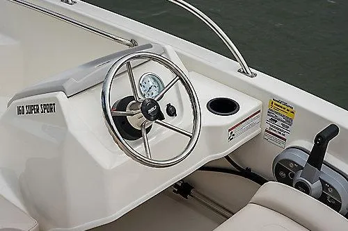 Slide: The Image of 2026 Boston Whaler 160 Super Sport boat dashboard with steering wheel and controls. - 4