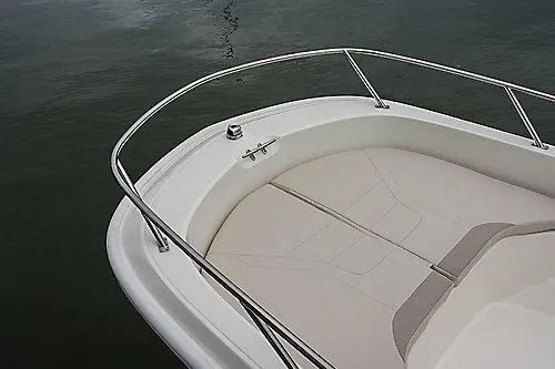 Slide: The Image of 2026 Boston Whaler 160 Super Sport boat bow with cushioned seating on calm water. - 8