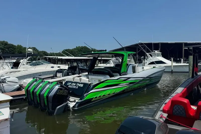 Slide: The Image of 2024 Deep Impact 399 Sport boat with vibrant green accents docked at a marina. - 4