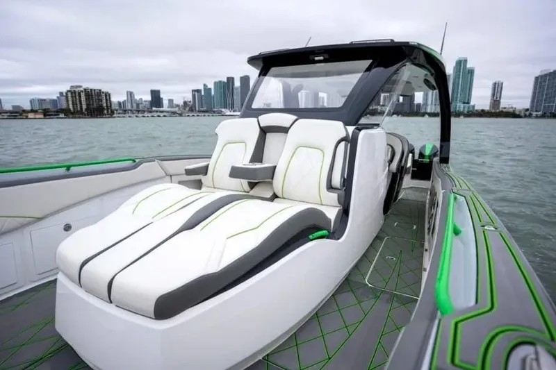 Slide: The Image of 2024 Deep Impact 399 Sport boat with luxurious seating, cruising near a city skyline. - 6
