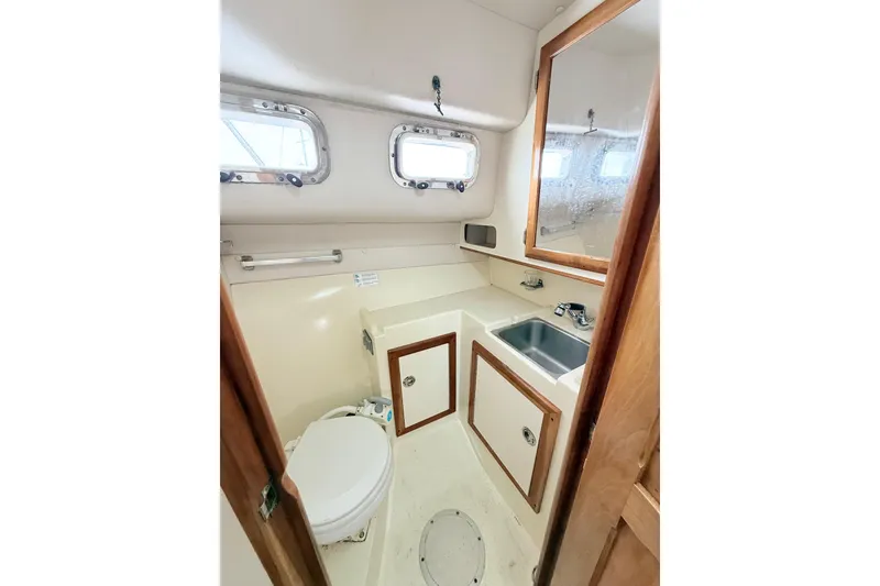 Slide: The Image of 2001 Albin 28 Tournament Express boat bathroom with sink, toilet, and storage cabinets. - 16