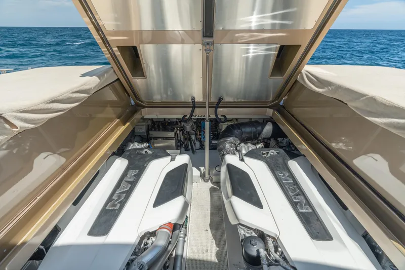 Slide: The Image of Engine compartment of 2019 CNM Continental 54 yacht with twin MAN engines, open hatch, ocean backdrop. - 40
