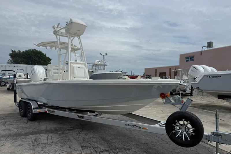 The Image of 2026 Pathfinder 2500 Hybrid boat on trailer, parked outdoors, showcasing sleek design. - 1