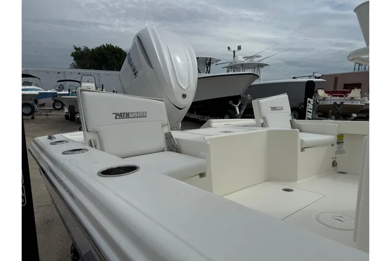 Slide: The Image of 2026 Pathfinder 2500 Hybrid boat interior with seating and motor, docked outdoors. - 11