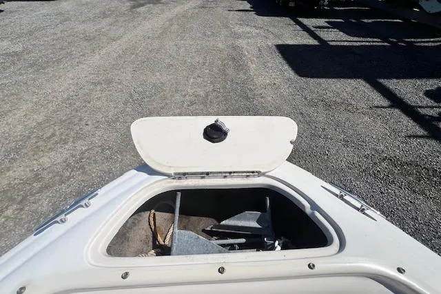 Slide: The Image of 2005 Sea Ray 185 Sport boat anchor compartment open on gravel surface. - 10