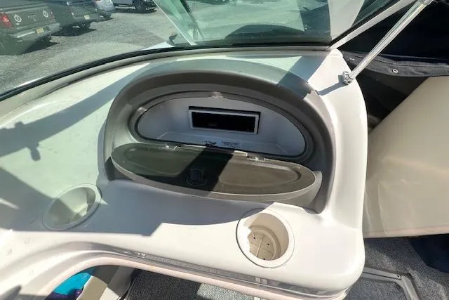 Slide: The Image of 2005 Sea Ray 185 Sport boat dashboard with storage compartment and cup holder. - 4